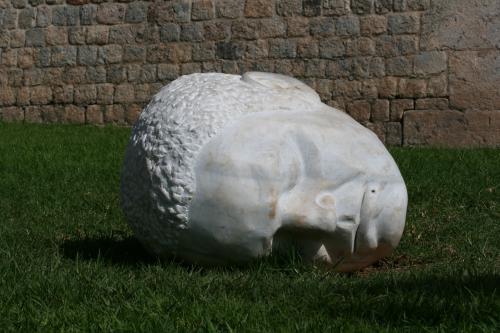 Stone head from a statue lying on grass